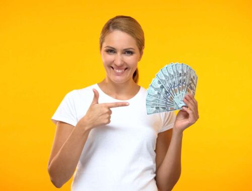 Women in yellow background showing money in hand