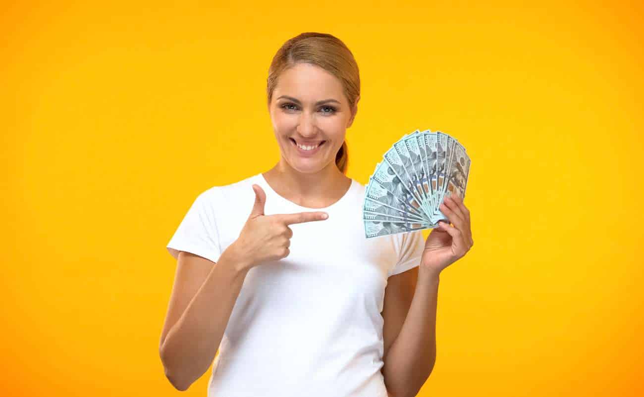 Women in yellow background showing money in hand